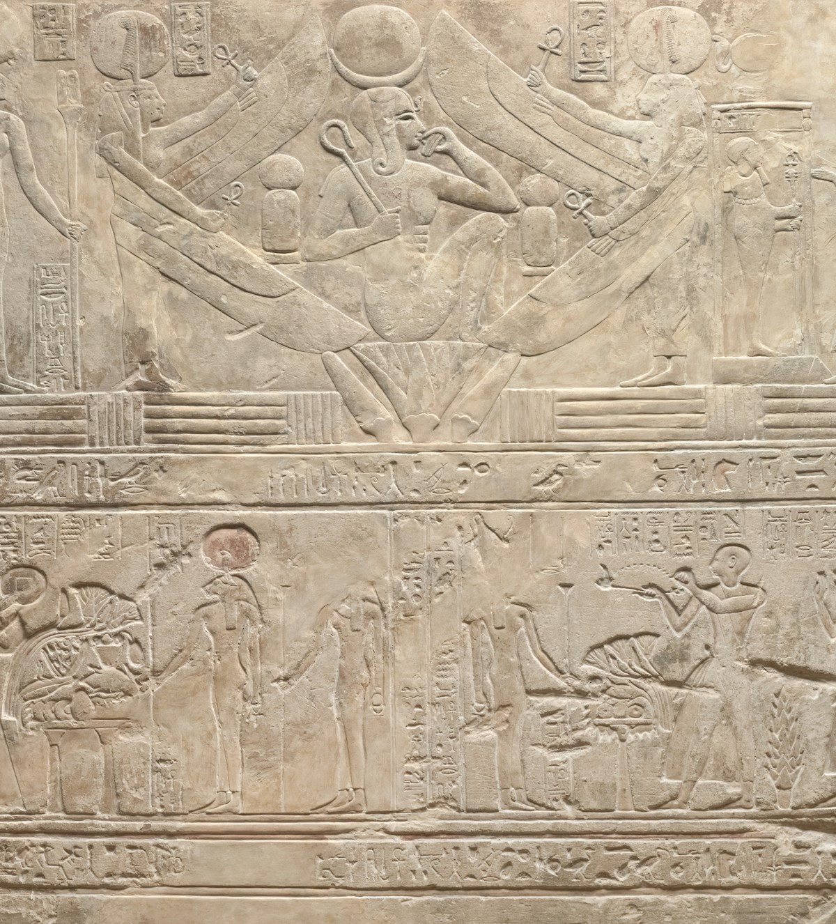 Hieroglyphic carvings on an ancient Egyptian temple wall showing pharaonic figures and cartouches